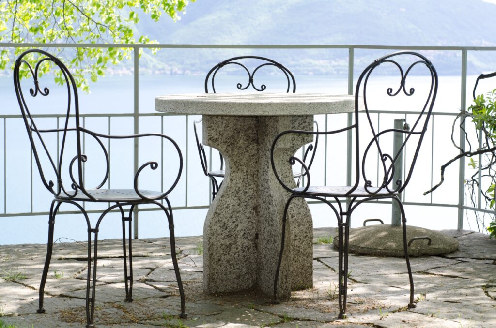 patio with a stone table and chairs with the view over a lake